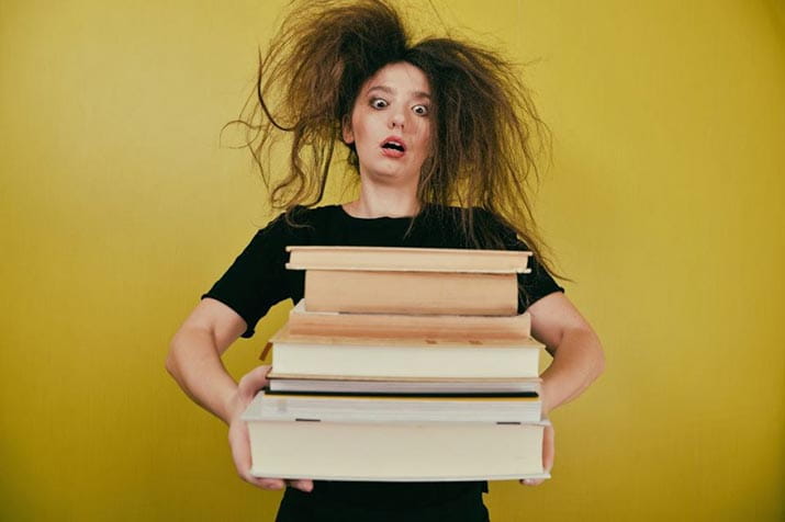female with crazy hair holding books
